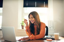 Businesswoman smiling in front of laptop in her office