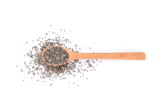 Chia seeds and wooden spoon isolated on plain background