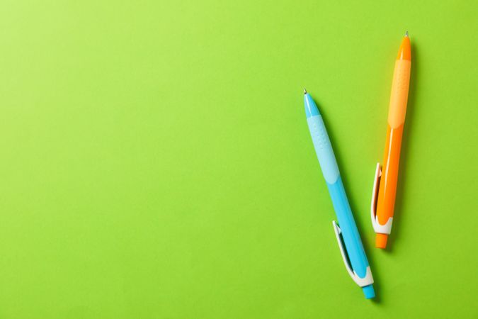 Pens on green background, space for text