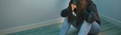 Woman with problems with hands in head sitting on the floor