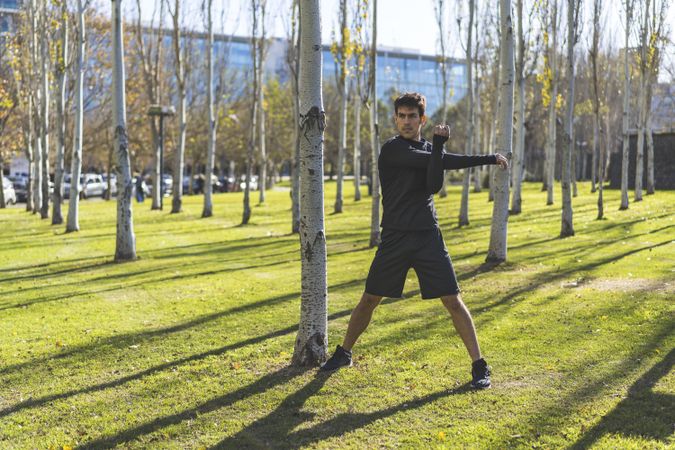 young man stretching arms before jogging. Copy space