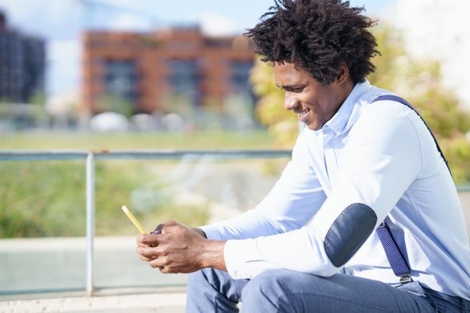 Man holding a yellow phone and smiling