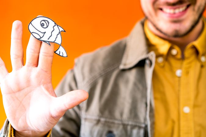 Smiling man holding funny paper toy