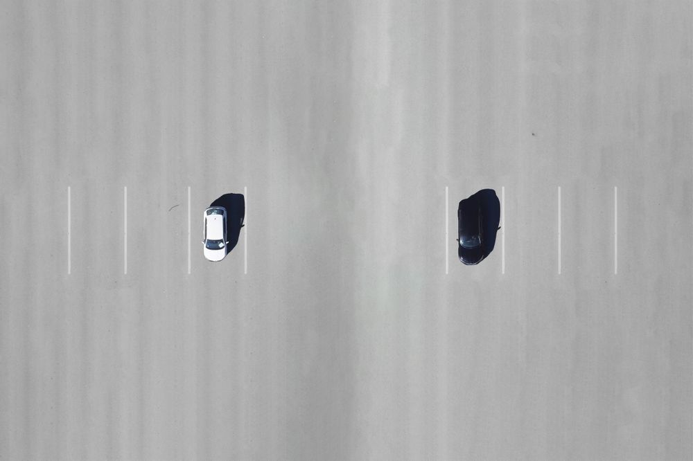 Two cars parked spaces apart, aerial view