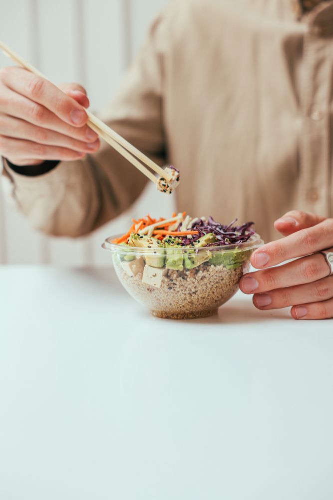 Cropped image of woman eating poke bowl