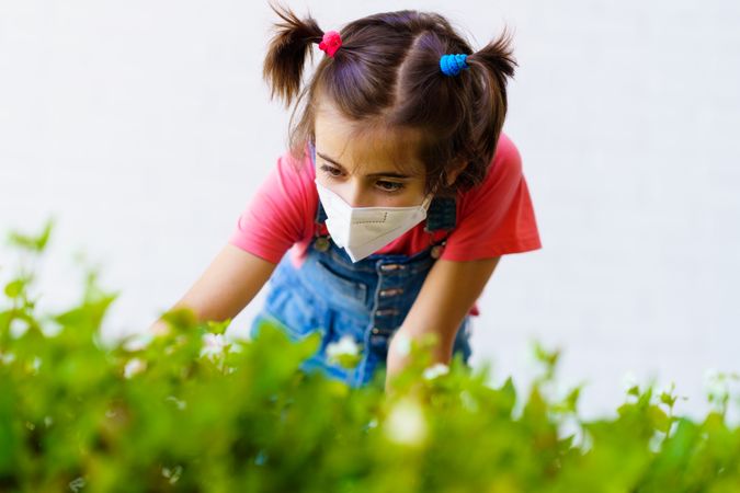 Girl gardening in PPE mask