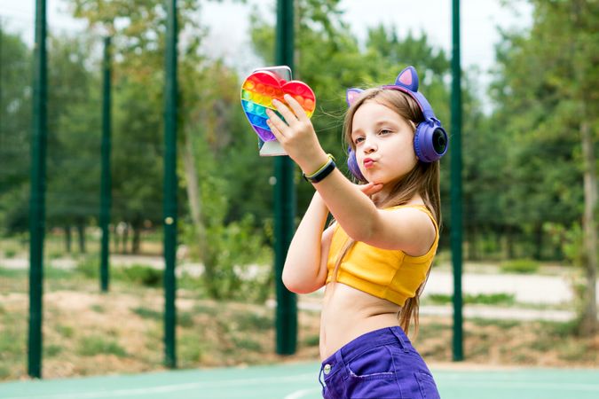 School girl with toy and smartphone