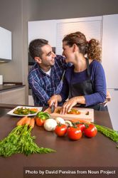 Couple joking together as they chop vegetables for meal 5oRP10