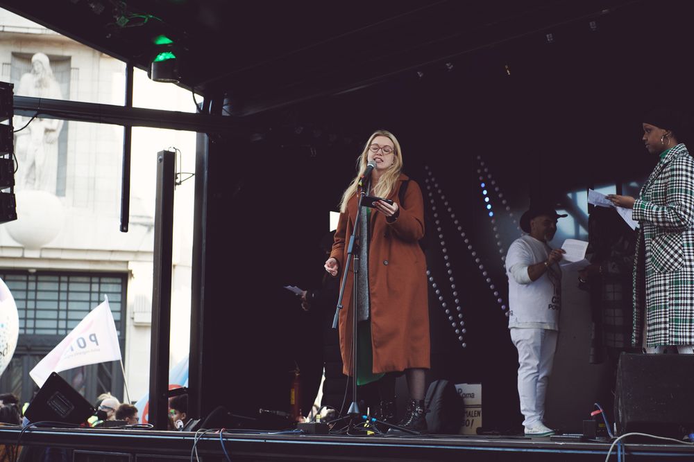 London, England, United Kingdom - March 19 2022: Blonde woman reading off phone on stage