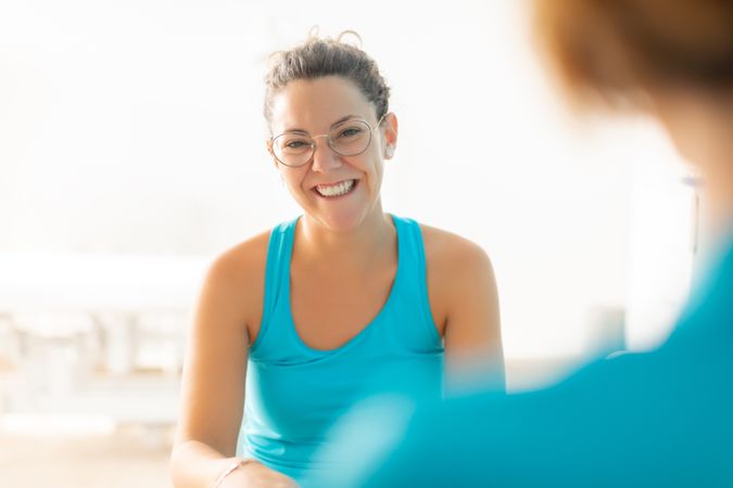 A young woman smiles as she talks during a consultation with her physical therapist