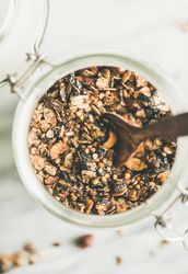 Top view glass container of homemade granola, close up