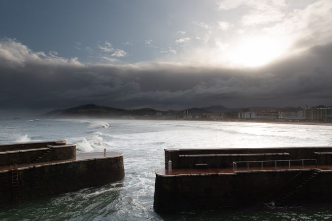 Rock breakwater with raging sea on cloudy weather
