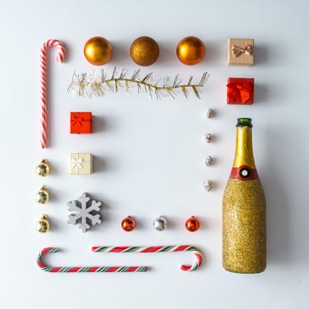 Christmas layout made of festive decorations, baubles, candy canes, Champagne on light background