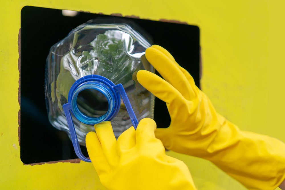 Person putting plastic bottle in recycling bin