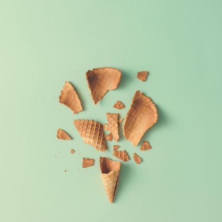 Shattered ice cream cone on pastel blue background