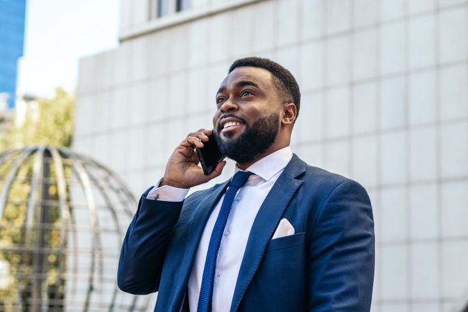 Business man in suit talking on the phone while leaving the office