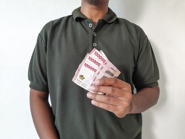 Person Holding Indonesian Rupiah Banknotes