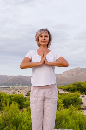 Barefoot woman meditating on stone