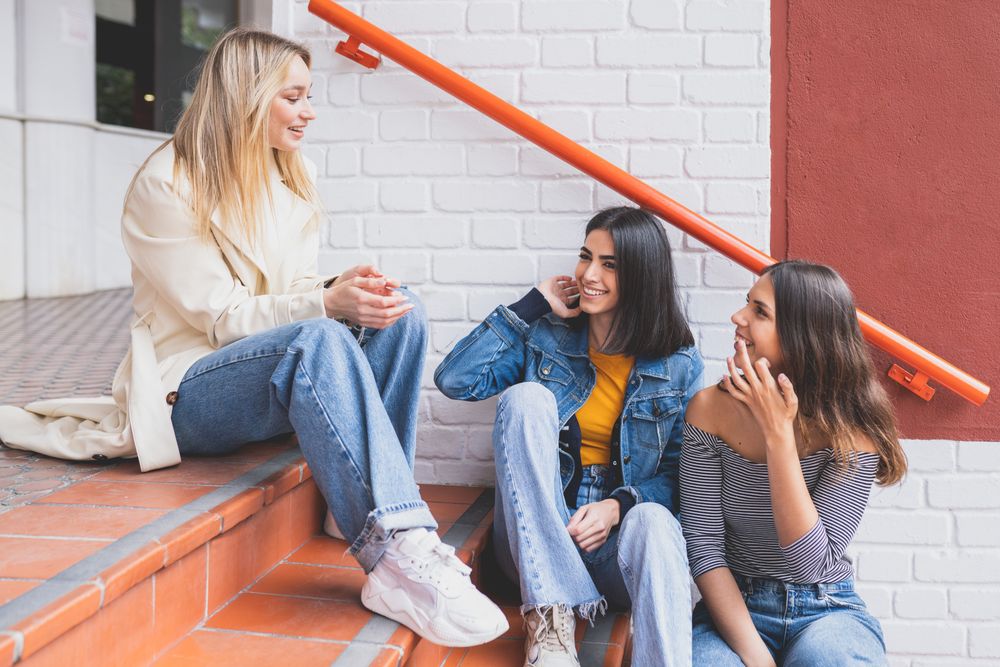 Three women having a conversation on outdoor brick steps
