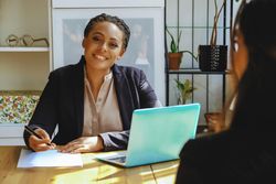 Woman business owner hosting a meeting with colleague in bright office