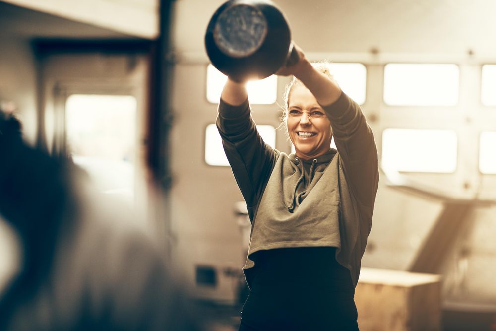 Woman smiling while swinging kettlebell