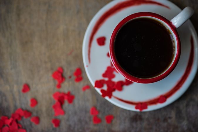 St. Valentine day card concept with top view of coffee with red heart confetti 