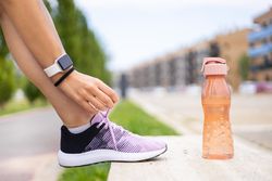 Female athlete tying running shoe laces for running workout
