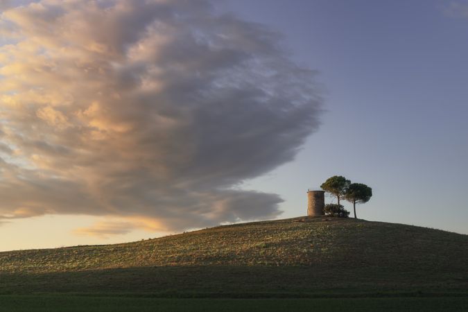 Tuscany, Maremma landscape, old windmill and trees on top of the hill