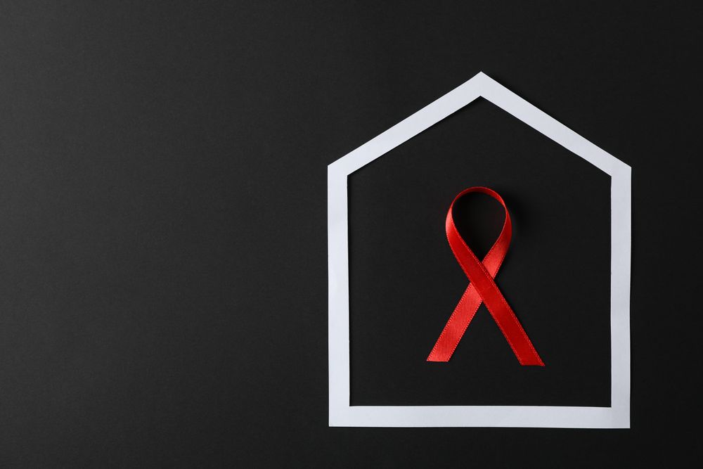 Awareness red ribbon in frame on dark background, copy space