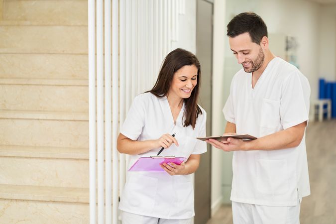 portrait of two physiotherapists looking at the following patien