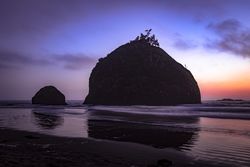 Two large rocks under gradient purple orange sky