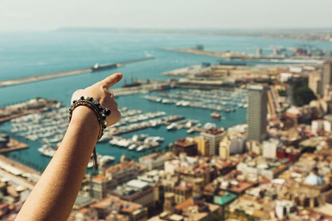 Hand pointing at sights of amazing coast