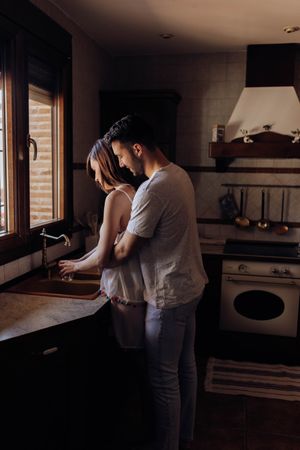Happy couple embracing in kitchen