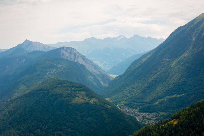 Densely populated town at foot of green mountains