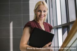 Smiling businesswoman with a file in office 0JGApp
