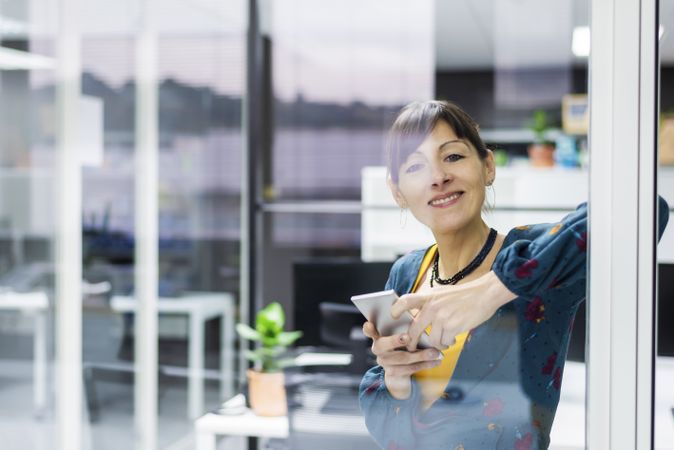 Woman browsing smartphone in office