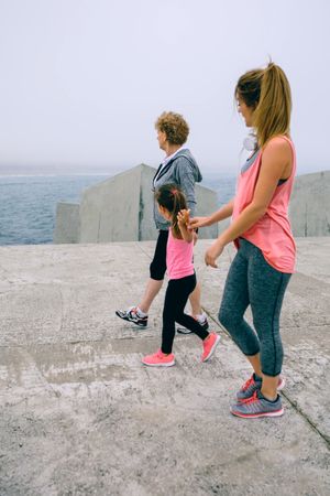 Three female generations walking by sea pier
