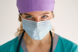 Female doctor in scrubs and mask