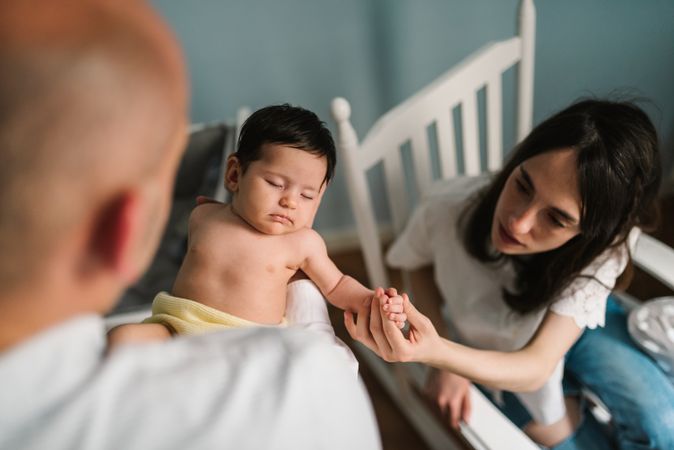 Parents holding baby in room