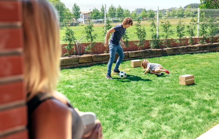 Mother watching her husband and son playing