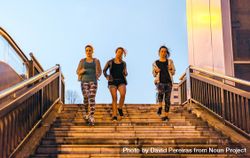 Women friends training running down stairs in town at sunset bDjPWp