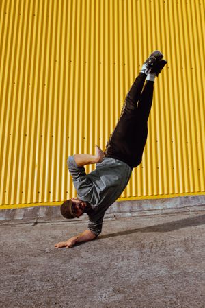 Man performing handstand near wall