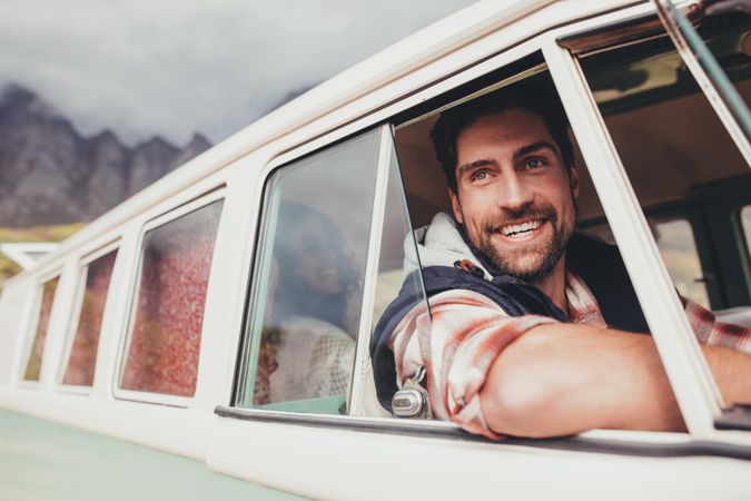 Smiling man driving a van and looking outside