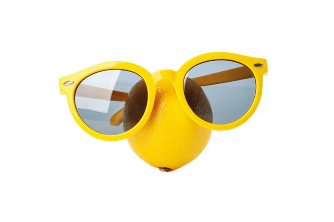 Lemon with sunglasses isolated on light background