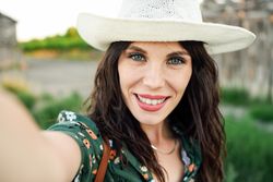POV of smiling brunette female taking a selfie
