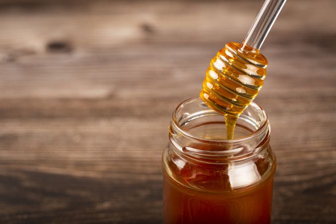 Honey in glass jar on the table.