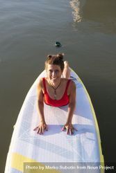 Smiling woman stretching back on paddleboard 5plry5