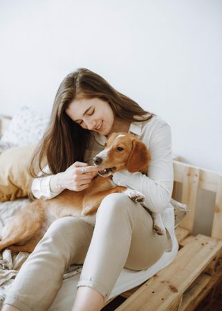 Portrait of a woman and a beagle dog sitting on bed