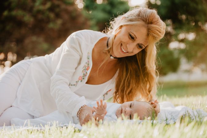 baby with down syndrome lying on a blanket with her grandmother