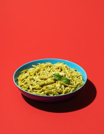Pasta with pesto minimalist on a red background